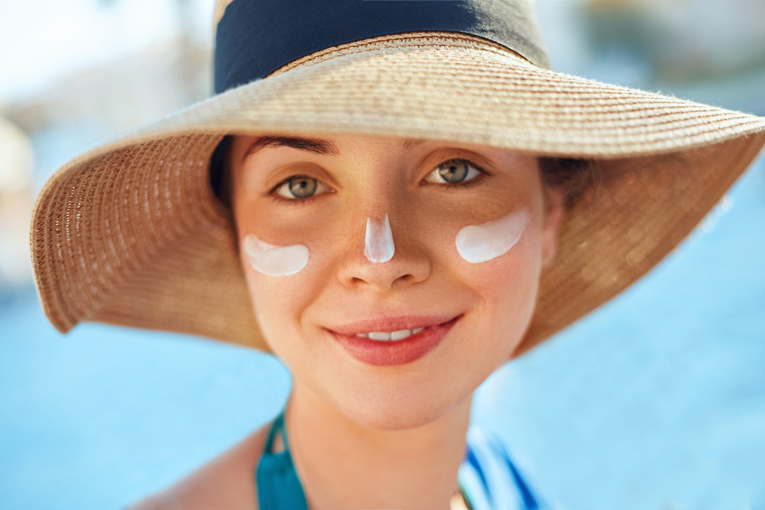 Suntan Lotion Woman Applying Sunscreen. Female smear  sun cream  on face. SkinCare.